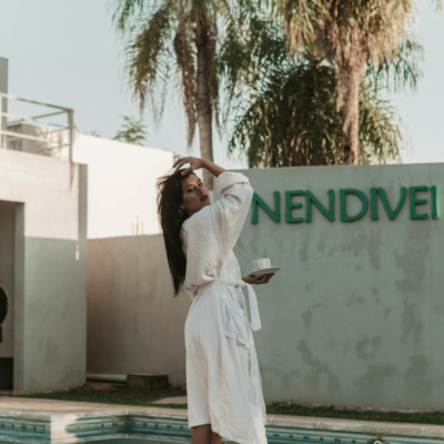 A serene outdoor scene featuring a woman in a bathrobe by a swimming pool, embracing a tranquil moment.